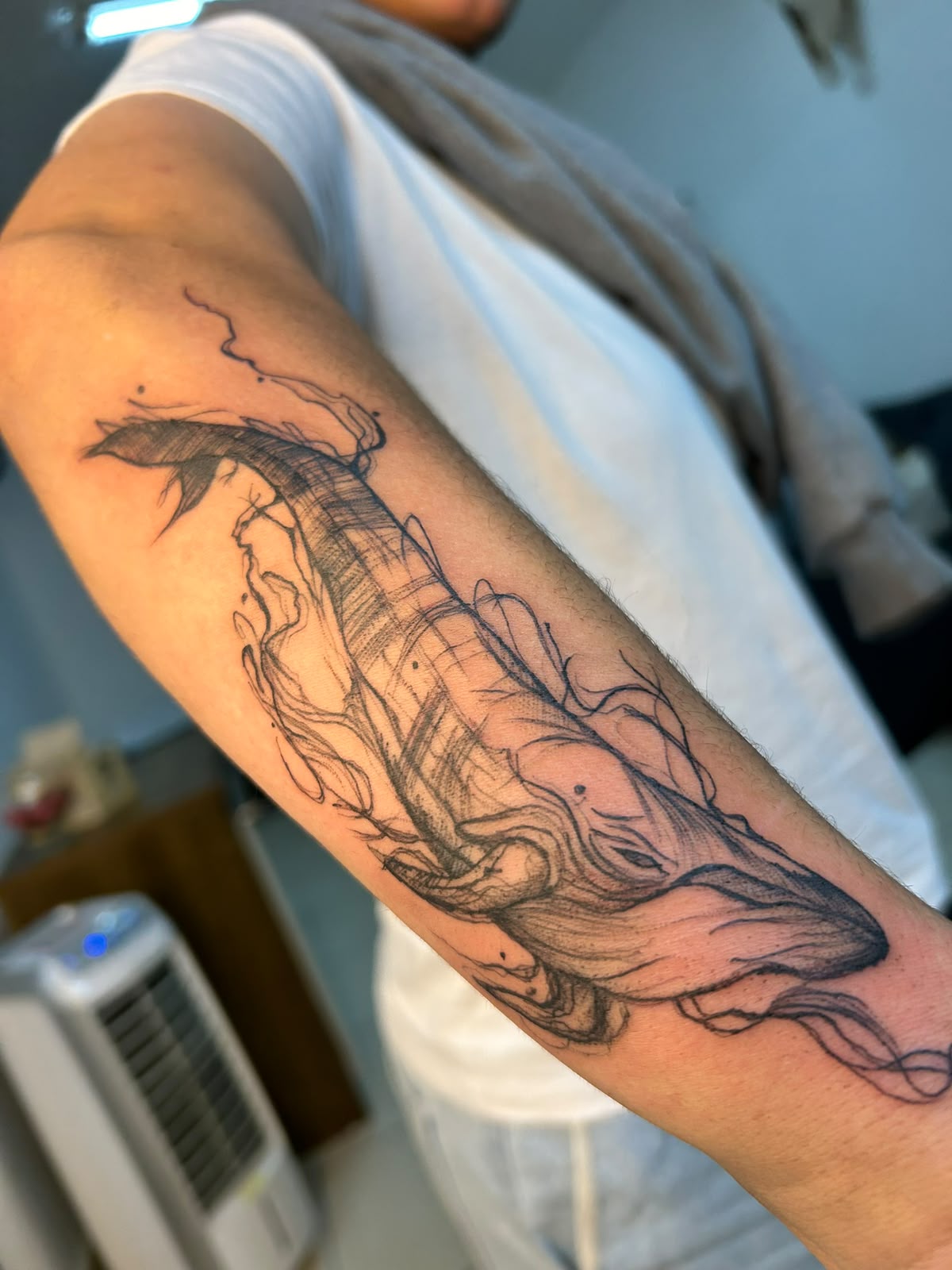 Tatuagem ilustrativa em preto no antebraço