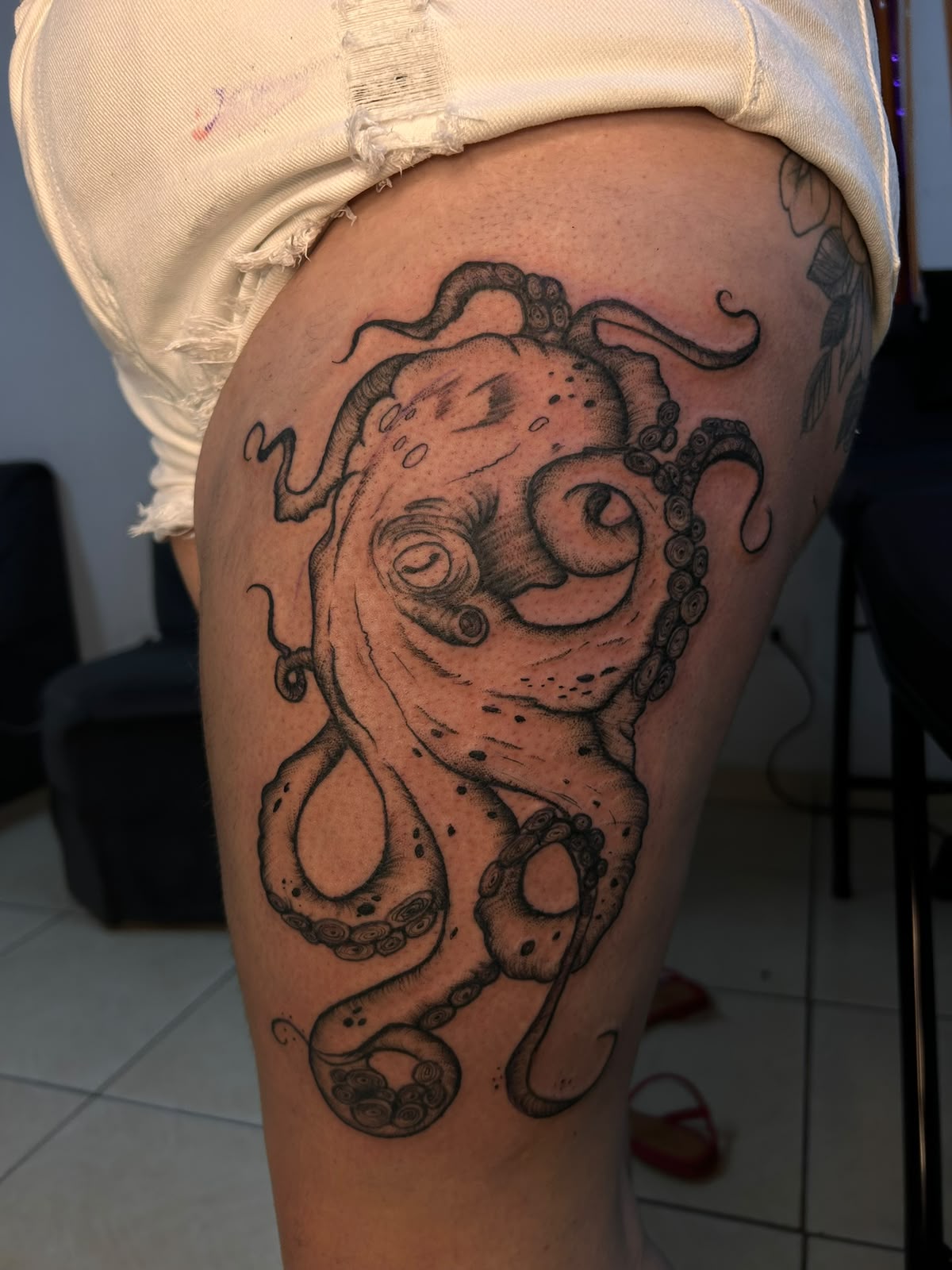 Tatuagem autoral de polvo na coxa